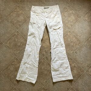 White bootcut / flared pants with a relaxed fit & button attachments for cuffing